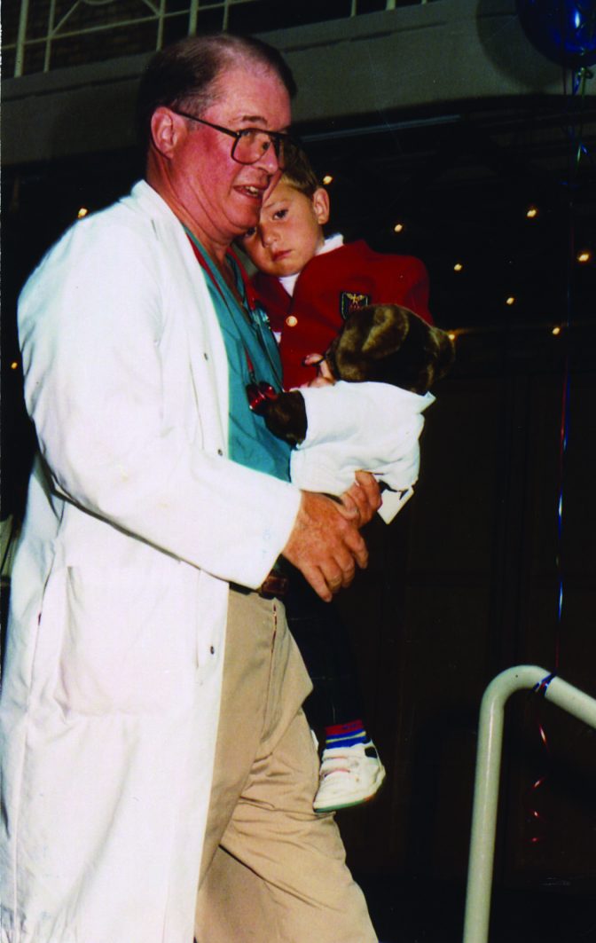 Dr.Nesbit holding a child and teddy bear