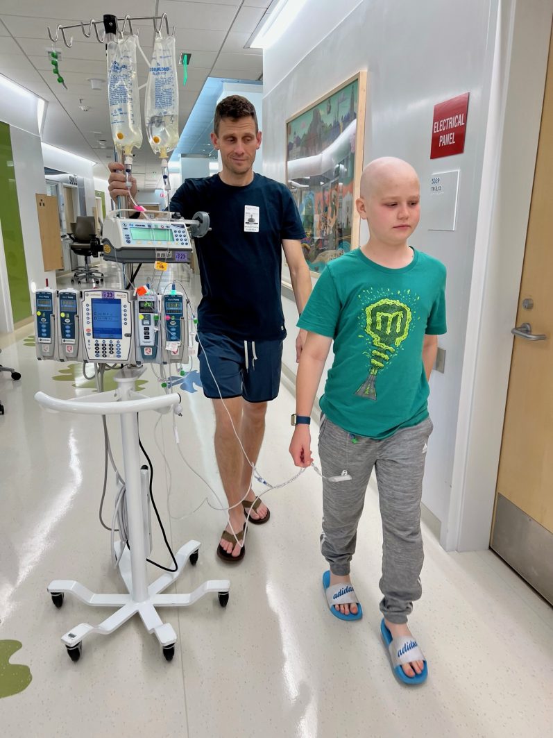 Max with his dad walking in the hospital hall